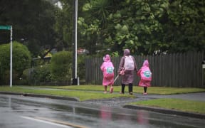 School children on their way to school during the storm, in West Harbour, Auckland.